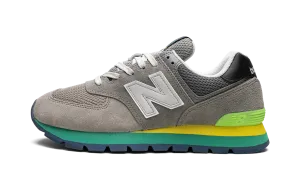574 Rugged "Rugged Grey Yellow Emerald" running in a marsh area shoes mid - top height